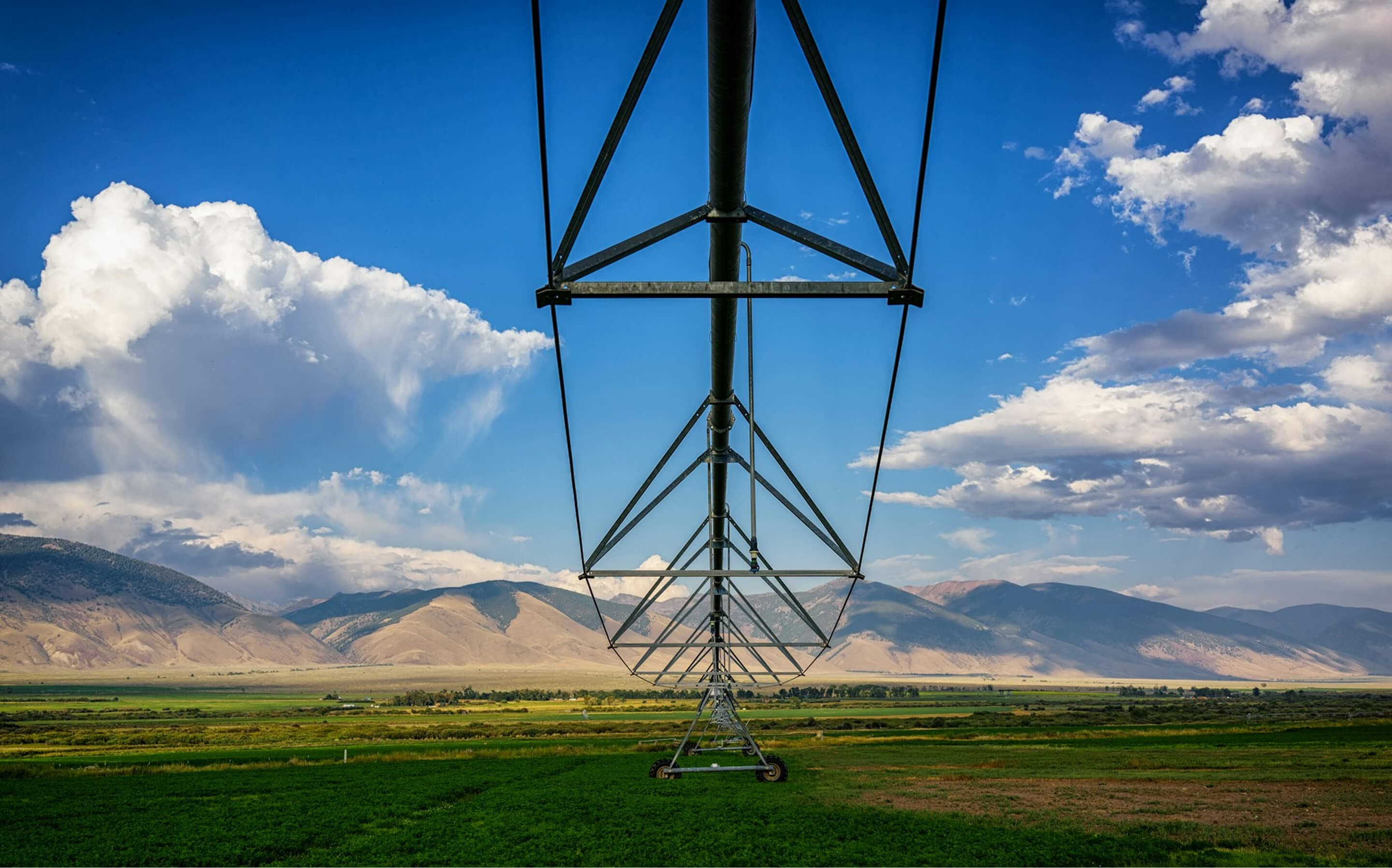 Une rampe d'irrigation au-dessus d'une vallée verte, sous des collines sèches